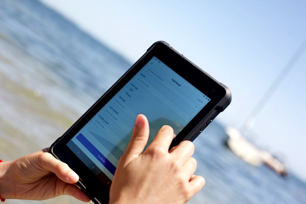 Tablette Sailproof affichant l'interface de l'application The Boat App avec des fonctionnalités tout-en-un pour la gestion des bateaux.