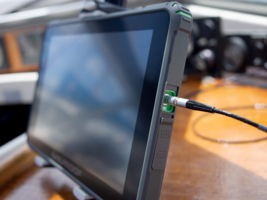 Close-up van de SailProof waterdichte oplaadconnector die stevig op de tablet is bevestigd, en toont een veilige en correcte verbinding.<br>