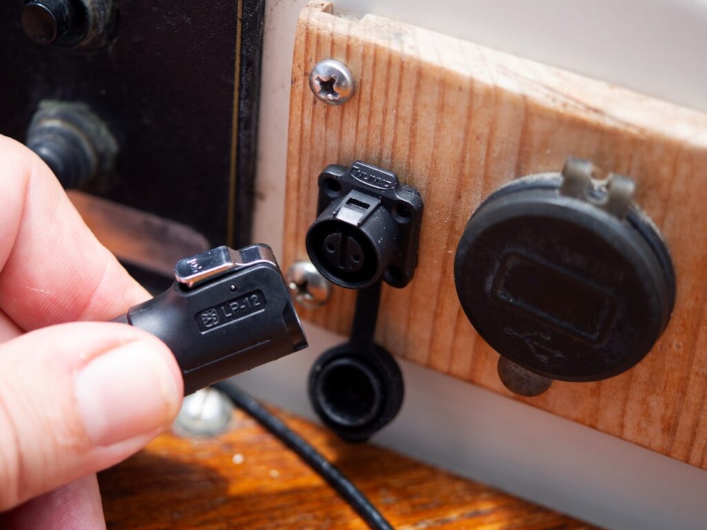 Waterdichte SP10XW-oplaadkabel aangesloten op het waterdichte stopcontact dat op de boot is geïnstalleerd, met een afgedichte en weerbestendige verbinding.<br>