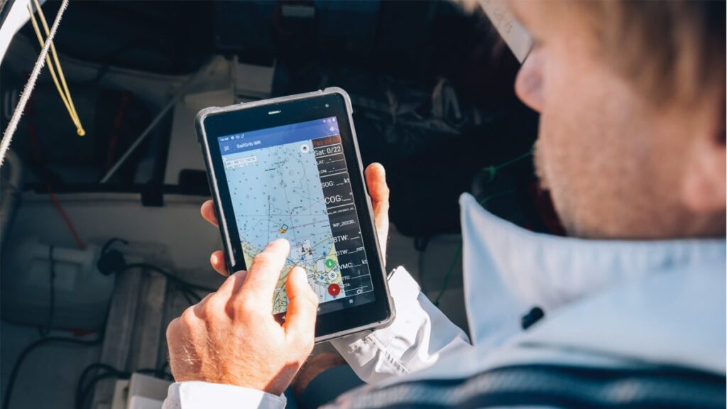 Skipper Alexis Thomas using a Sailproof tablet with the SailGrib app on board his sailboat.