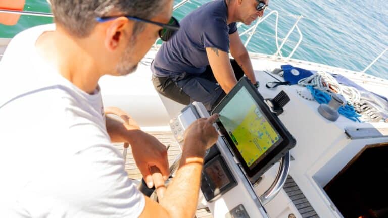 Kapitein navigeert met een SailProof-tablet die op het roer is gemonteerd met behulp van een Rokk-houder.