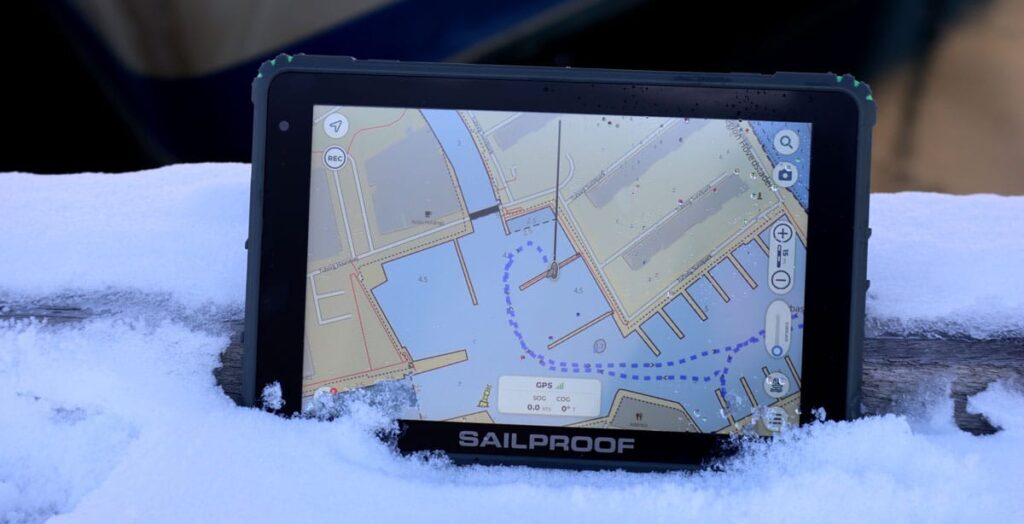 SailProof tablet running Aqua Map navigation app placed on snow, showing its durability and reliability in cold marine environments.